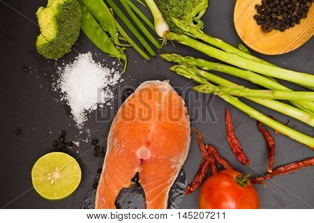 Fresh Raw Salmon Filet With Spicy Herbs On Black Plate