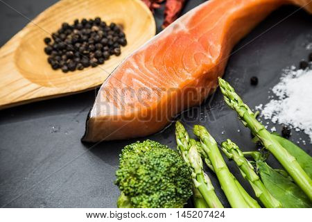 Fresh Raw Salmon Filet With Spicy Herbs On Black Plate