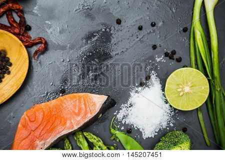 Fresh Raw Salmon Filet With Spicy Herbs On Black Plate