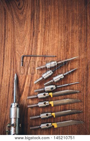 Closeup of a collection of hand engraving tools sitting on a table in a jewelery workshop