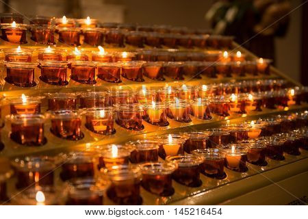 Prayer candles light up the darkness in a church
