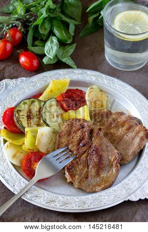 Grilled Steak Meat Pork And Grilled Vegetables On Brown Stone Background.
