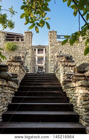 Wooden stairs in a castle with stone walls at orheiul vechi vila etnica in Moldova