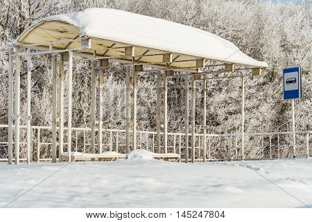Empty suburban bus stop covered with snow in winter