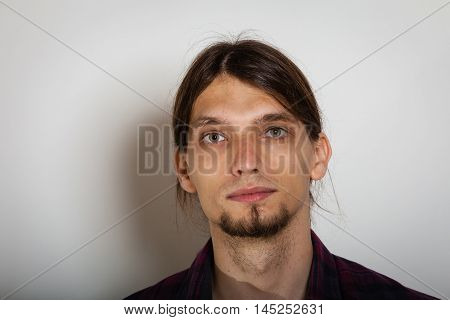 Masculinity concept. Face of young man. Bearded youthful male with long hairs.