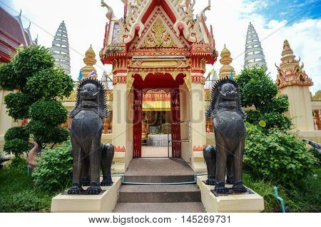 Roiet Thailand - Aug 23 2016 : Two Khmer-style lion statue in front of the gate at Burapapiram Temple