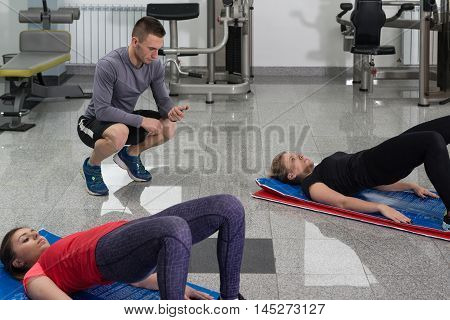 Group Of Smiling People Exercising In The Gym