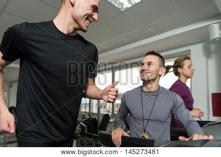 Group Of People Running On Treadmills In Gym