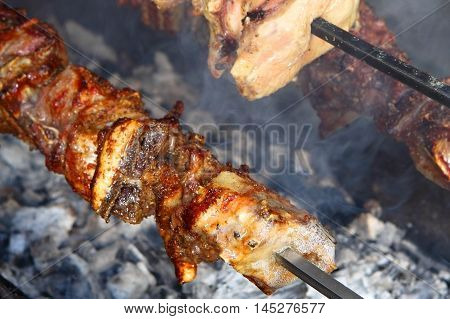 Juicy meat cooking on rotisserie 3/4 view