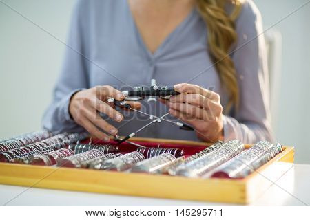 Mid section of woman preparing messbrille in optical store
