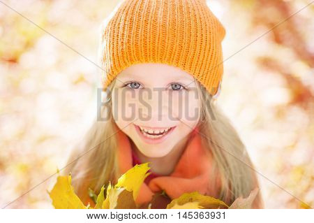 girl in an orange cap smiles and glad a autumn
