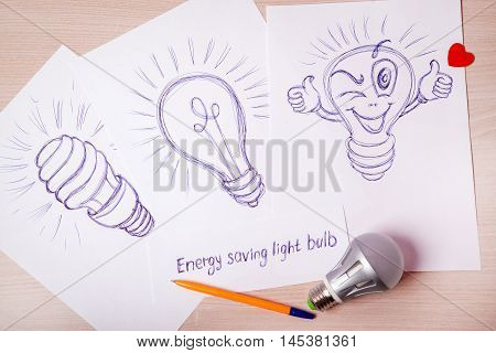 Cartoon energy-saving light bulbs painted pen on a sheet of paper. The lamp bulb