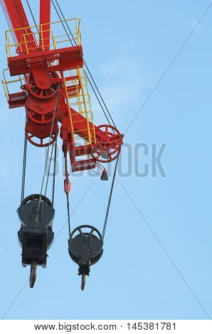 Red and Black Colored Heavy Crane Pulleys Against Blue Sky