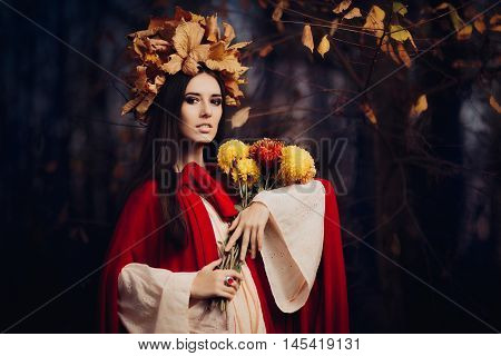 Beautiful Woman With Autumn Leaves Crown Holding Flowers