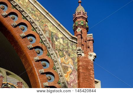 Beautiful mosaic depicting couple with grapes on facade of historic market Colon in Valencia, summer Spain