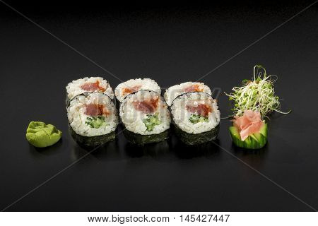 fresh made Japanese sushi rolls with tuna and cucumbers decorated with wasabi and seaweed salad