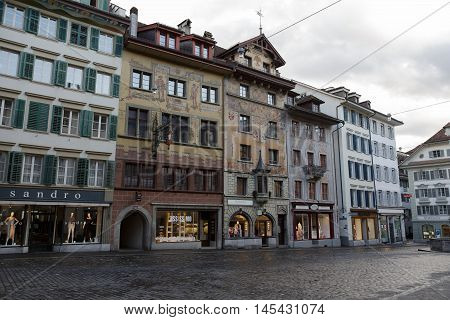 Lucerne Switzerland - May 03 2016: Colorful frescos decorate historic buildings on Weinmarkt. Despite the rainy weather the colors of the city show a variety of tourist attractions. These attractively decorated buildings are located almost in the center o