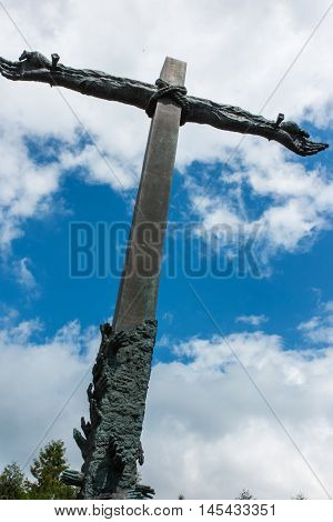 Dukla Poland - July 22 2016: Cross reconciliation entwined hands pleading wreath consecrated by Pope John Paul II in honor of those who died in the Second World War and on the ground Dukla