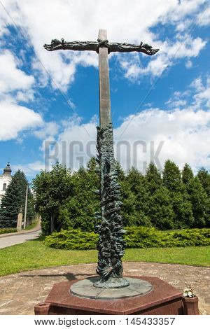 Dukla Poland - July 22 2016: Cross reconciliation entwined hands pleading wreath consecrated by Pope John Paul II in honor of those who died in the Second World War and on the ground Dukla