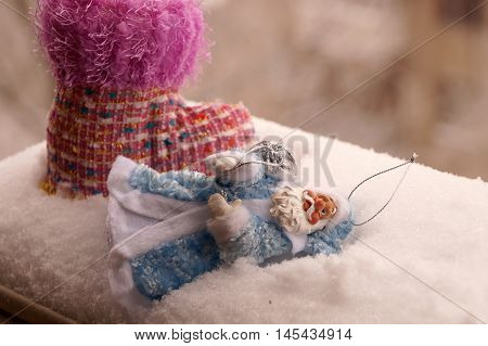 Toy Father Frost in a blue fur coat with a silvery bag