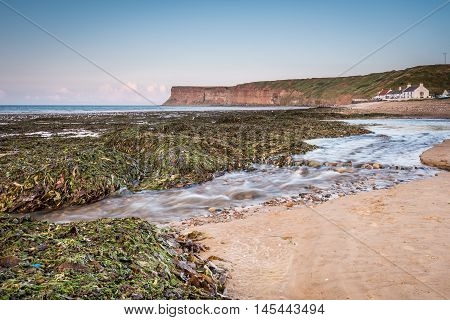 Skelton Beck and Saltburn Scar, which flows over Saltburn Sands into the North Sea with Saltburn Scar behind