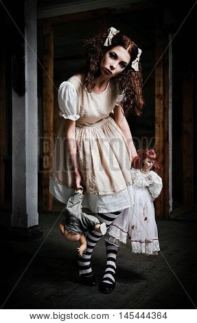 The strange scary girl with dolls in hands