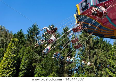 Biddinghuizen, The Netherlands - August 24, 2016: High speed carousel with park visitors during a ride at Walibi theme park.