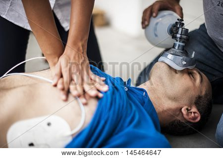 operators assisting an unconscious man with cardiopulmonary resuscitation and heart massage