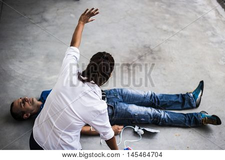 girl assisting an unconscious man after heart attack