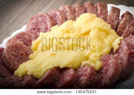 pork sausage (cotechino) with polenta on the wood table