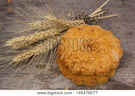 Fresh crispy cereal cookies and ears on rustic wooden table .