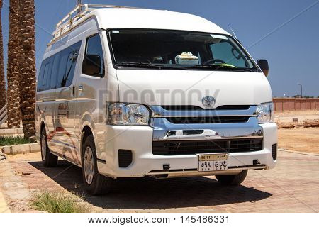 EGYPT, SHARM EL SHEIKH - JULY 20, 2015: Sharm el-Sheikh is holiday resort and significant centre for tourism in Egypt. White commercial passenger mini bus waiting for tourists