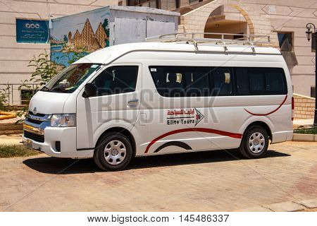 EGYPT, SHARM EL SHEIKH - JULY 20, 2015: Sharm el-Sheikh is holiday resort and significant centre for tourism in Egypt. White commercial passenger mini bus waiting for tourists