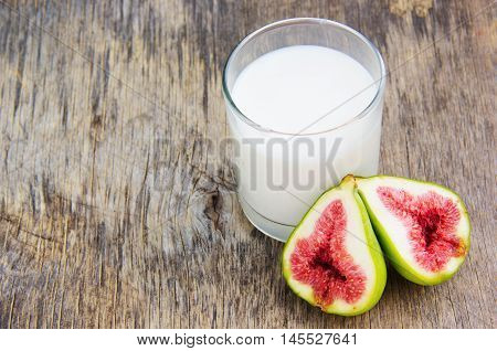 Fresh figs on wooden ground and a glass of milk