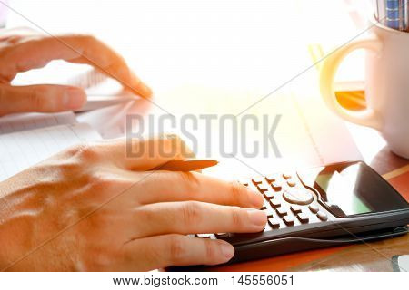 savings finances economy and home concept - close up of man with calculator counting making notes at home soft focus.