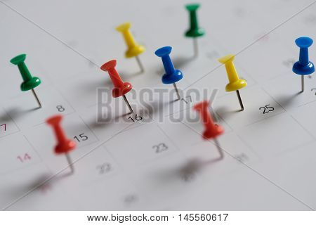 Colourful pushpin on calendar for important date.