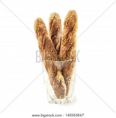 Three fresh home baked Alpine Baguettes with different cereals and seeds in glass jug isolated over white. Healthy food concept.Three fresh home baked baguettes in glass jug on white.