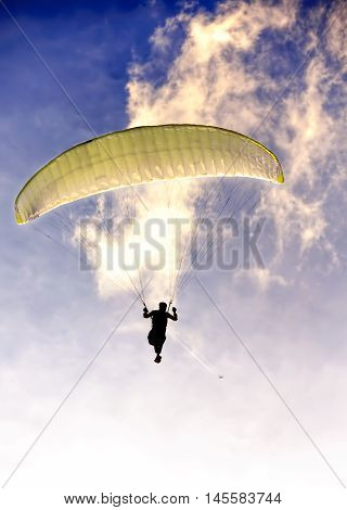 Green parachute at sunset silhouetted feeling freedom