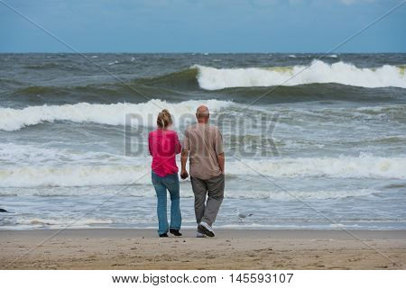 Spring Lake NJ US -- Sept 3 2016. A couple stands on the beach watching the ocean churn before an impending storm . Editorial Use Only.