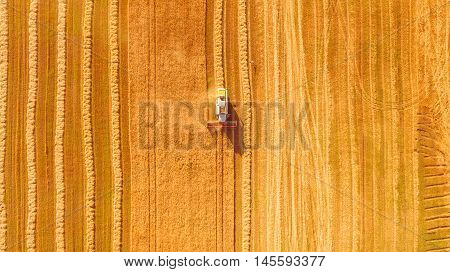 Harvester machine working in field . Combine harvester agriculture machine harvesting golden ripe wheat field. Agriculture. Aerial view. From above.
