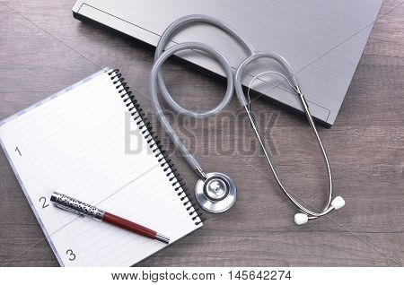 Doctor workplace with a stethscope at wooden table