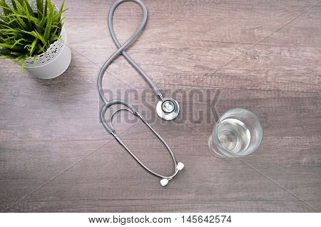 Stethscope isolated on wooden background with flower