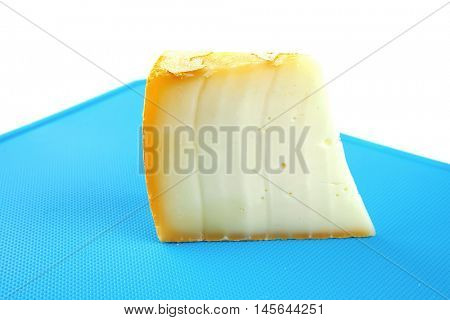 light swiss gauda cheese on blue board