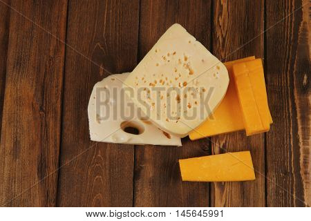 various types of fresh raw aged delicatessen cheese on wooden table cheddar edam swiss