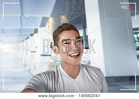 Young asian man pose selfie in airport lobby alone smile expression and cheerful