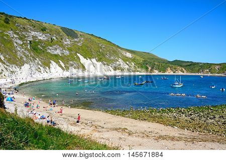 LULWORTH COVE, UNITED KINGDOM - JULY 19, 2016 - View of the beach and cove with holidaymakers enjoying the setting Lulworth Cove Dorset England UK Western Europe, July 19, 2016.
