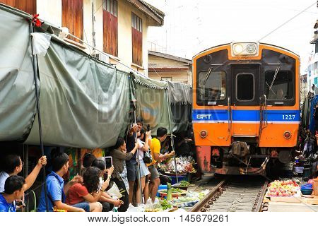 SAMUT SONGKHRAM THAILAND - SEPTEMBER 4 2016 : Mae Klong Market placed all product on railroad all vendors have to move product away when the train passes market.