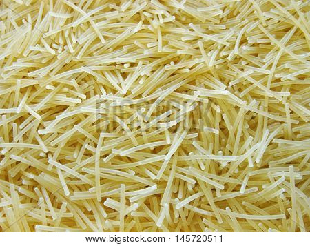 Scattered dry vermicelli. A lot of vermicelli. Pasta. Pasta as a background. Food. Product. Background.