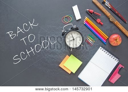 Back to school written on a chalkboad with stationery accessories