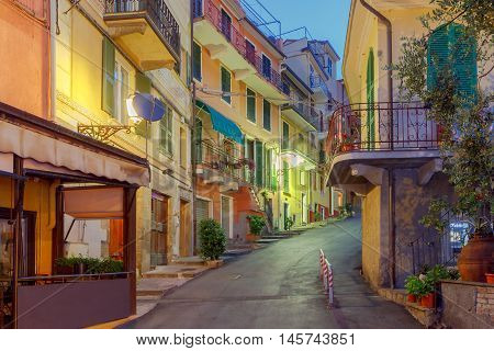 The old, narrow street in the medieval Italian village of Manarola at night. Parco Nazionale delle Cinque Terre, Liguria, Italy.